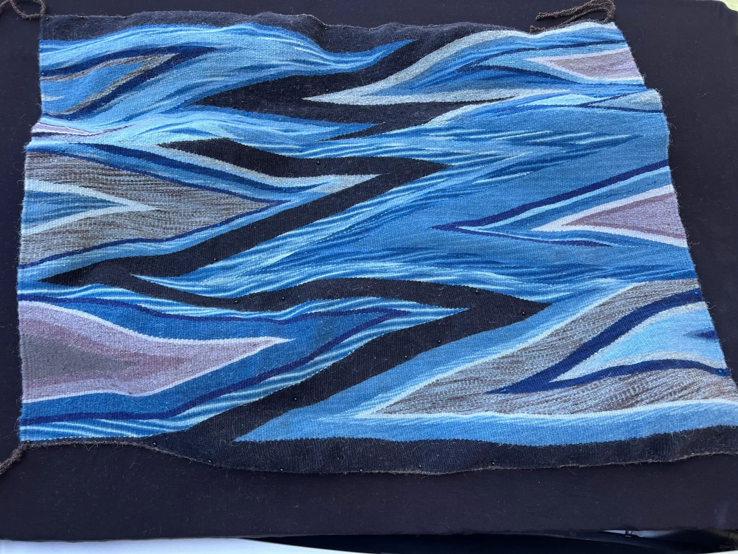 Abstract textile with wavy blue and gray brushstroke patterns